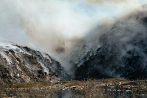 une montagne couverte de fumée à côté d'un plan d'eau