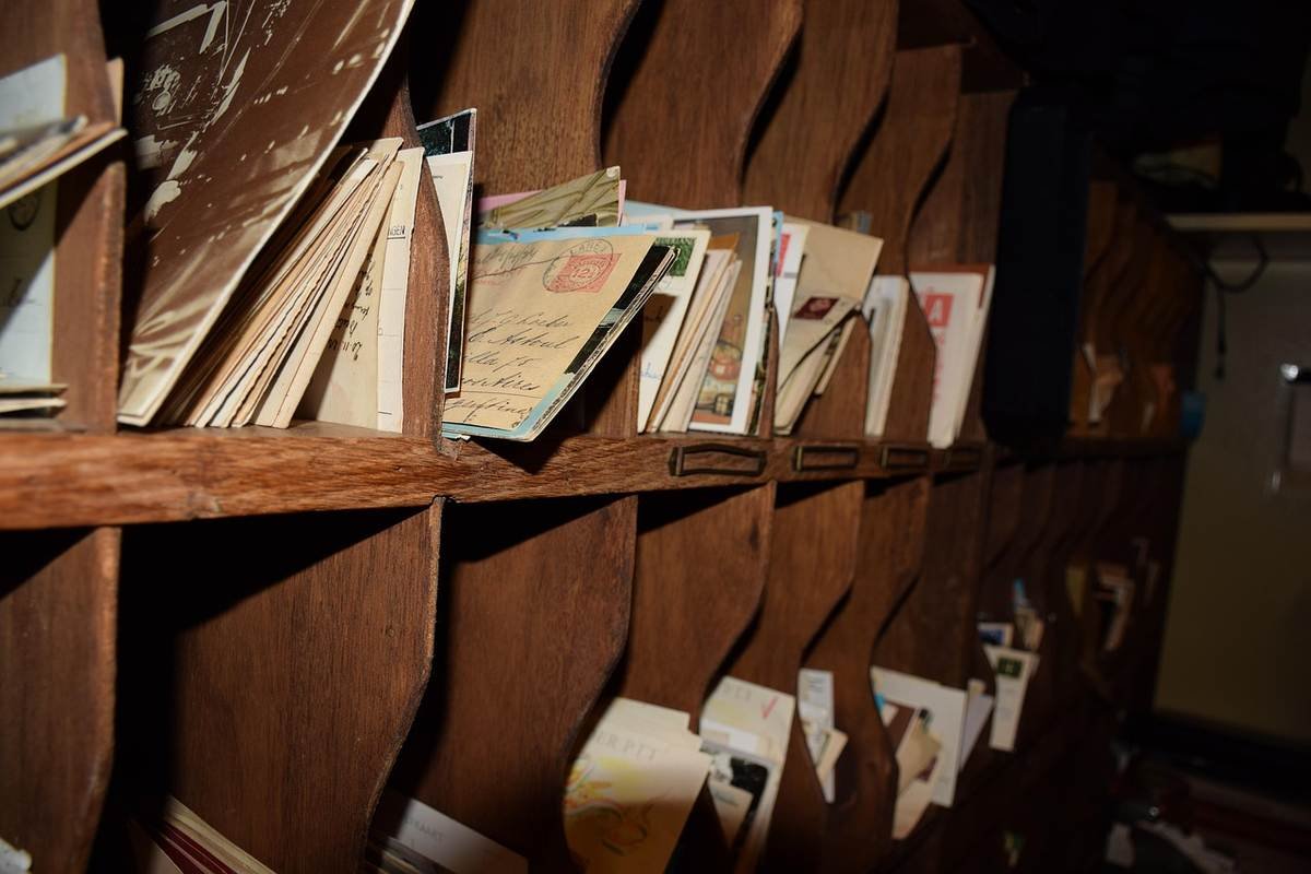 Des étagères en bois remplies de lettres et enveloppes