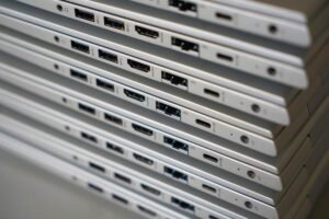 Empilement d'ordinateurs portables montrant leurs ports sur une surface blanche