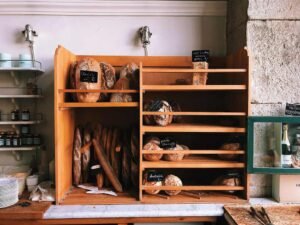 Étagères en bois exposant pains et pâtisseries dans une boulangerie