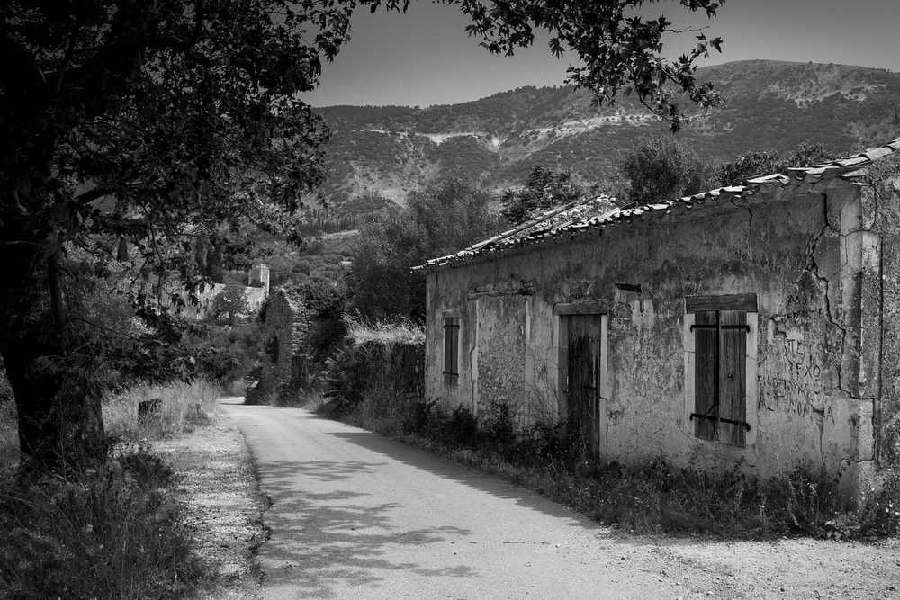Une route sinueuse mène à une maison vétuste au pied des collines