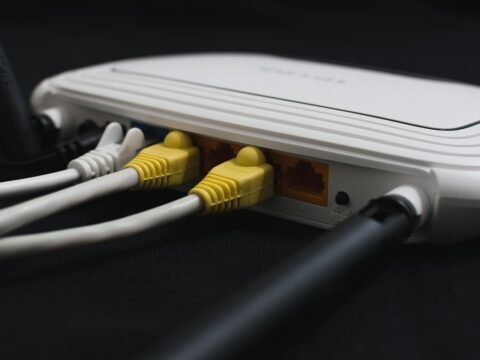 Un routeur blanc avec câbles Ethernet jaunes et blancs branchés