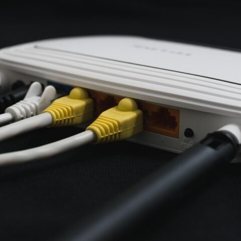 Un routeur blanc avec câbles Ethernet jaunes et blancs branchés