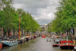 Vue d'un canal bordé d'arbres, de bateaux et de bâtiments anciens