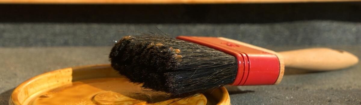 Un pinceau reposant sur un couvercle de pot de peinture