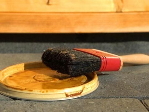 Un pinceau reposant sur un couvercle de pot de peinture
