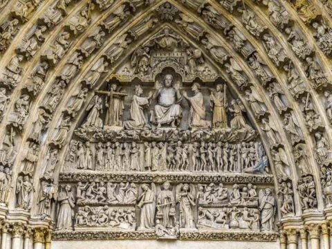 Portail en pierre orné de bas-reliefs sculptés représentant des scènes religieuses