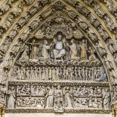 Portail en pierre orné de bas-reliefs sculptés représentant des scènes religieuses