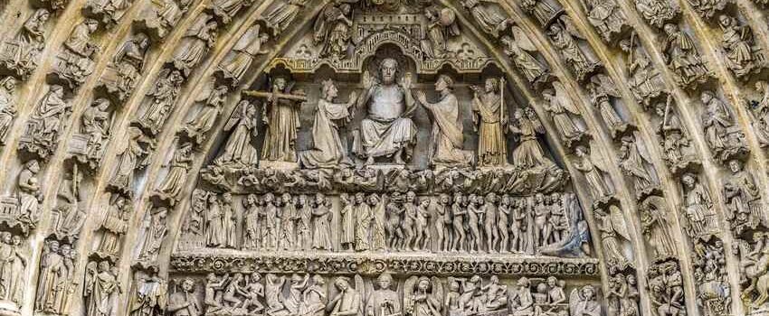 Portail en pierre orné de bas-reliefs sculptés représentant des scènes religieuses