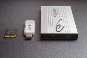 Carte SD, clé USB, et boîtier externe sur fond gris