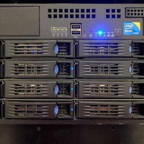 Baie de serveurs informatiques avec voyants lumineux bleus allumés et disques durs